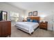 Cozy main bedroom with a wooden bed frame, soft carpet, and ample natural light at 5356 Diplomat Ct # 105, Kissimmee, FL 34746