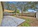 Fenced backyard with a concrete patio, shady awning, and leaves on the ground at 5424 Pinto Way, Orlando, FL 32810