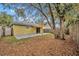 Backyard with a concrete patio, awning, wooden fence, and leaves on the ground at 5424 Pinto Way, Orlando, FL 32810