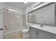 Neutral bathroom with a shower-tub combo, a big mirror, and modern vanity at 5424 Pinto Way, Orlando, FL 32810