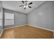 Cozy bedroom with hardwood floors, a ceiling fan, and a large window overlooking the backyard at 5424 Pinto Way, Orlando, FL 32810