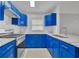 Close up of modern kitchen with blue cabinets, stainless steel appliances, and a stylish subway tile backsplash at 5424 Pinto Way, Orlando, FL 32810