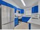 Modern kitchen showcases blue cabinets, stainless steel appliances, and subway tile backsplash at 5424 Pinto Way, Orlando, FL 32810