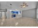 Open-concept living space with tile flooring leading into a kitchen with blue cabinets and stainless steel appliances at 5424 Pinto Way, Orlando, FL 32810