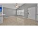 Bright living area featuring tile floors, a ceiling fan, and a large window for natural light at 5424 Pinto Way, Orlando, FL 32810