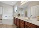 Bright bathroom features tile flooring, a soaking tub, and a vanity with double sinks at 620 Orange Cosmos Blvd, Davenport, FL 33837