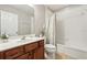 Bathroom with a tiled tub and shower, cherry cabinet and neutral tones at 620 Orange Cosmos Blvd, Davenport, FL 33837