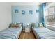 Charming bedroom with twin beds, nautical decor, and light blue walls at 620 Orange Cosmos Blvd, Davenport, FL 33837