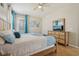 Bedroom features wood floors, blue bedding, a ceiling fan, windows, and a wood dresser with a mirror at 620 Orange Cosmos Blvd, Davenport, FL 33837