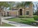 Charming two-story home featuring a well-manicured lawn, mature trees, and a two-car garage at 620 Orange Cosmos Blvd, Davenport, FL 33837