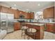 Kitchen includes wooden cabinets, stainless steel appliances, granite countertops, tile backsplash, and an island with seating at 620 Orange Cosmos Blvd, Davenport, FL 33837