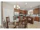 An eat-in kitchen features wood cabinets, stainless steel appliances, granite countertops, and a glass dining table at 620 Orange Cosmos Blvd, Davenport, FL 33837