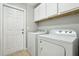 Bright laundry room with a utility sink, white cabinets and appliances at 620 Orange Cosmos Blvd, Davenport, FL 33837