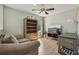 Bright living room with hardwood floors, built-in shelves, couch, desk and ceiling fan at 620 Orange Cosmos Blvd, Davenport, FL 33837