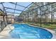 Backyard view featuring a screened-in pool, patio, and green yard at 620 Orange Cosmos Blvd, Davenport, FL 33837