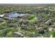 An aerial view of a community with lush trees, pond with fountain, and community pool at 629 Dory Ln # 303, Altamonte Springs, FL 32714