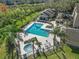 Aerial view of community pool with mature landscaping, jacuzzi, and lounge chairs at 629 Dory Ln # 303, Altamonte Springs, FL 32714