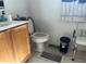 Bright bathroom features a wood vanity, toilet, and accessible seat at 6743 Sw 129Th St, Ocala, FL 34473