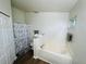 Bright bathroom featuring a tub with tile surround and a shower with a gray and white patterned curtain at 730 Garberia Dr, Davenport, FL 33837