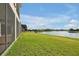 A sprawling green lawn leads to a serene lake view from this home at 890 Spinnaker Way, Kissimmee, FL 34746