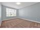 Bedroom with neutral carpet and blue walls featuring a large window at 890 Spinnaker Way, Kissimmee, FL 34746