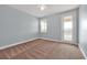 Bright bedroom with neutral carpet, light blue walls, ceiling fan, and a glass door to a balcony at 890 Spinnaker Way, Kissimmee, FL 34746