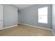 Bright bedroom with neutral tile flooring, a window for natural light, and soft blue walls at 890 Spinnaker Way, Kissimmee, FL 34746