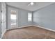 Bright bedroom with neutral carpet, light blue walls, ceiling fan, and a glass door to a balcony at 890 Spinnaker Way, Kissimmee, FL 34746