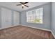 Bedroom featuring neutral carpet, light blue walls, and a large window with closet doors at 890 Spinnaker Way, Kissimmee, FL 34746