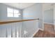 Hallway with wood and white railing overlooking a carpeted stairway, and a window with natural light at 890 Spinnaker Way, Kissimmee, FL 34746