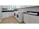 Bright laundry room featuring white washer and dryer, a sink, and ample counter space at 890 Spinnaker Way, Kissimmee, FL 34746