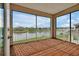 Covered patio overlooking a serene pond, featuring a screened enclosure and brick pavers at 890 Spinnaker Way, Kissimmee, FL 34746