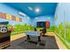 Bright game room featuring custom Super Mario themed wall murals, foosball table, and arcade game at 8900 Candy Palm Rd, Kissimmee, FL 34747