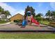 Community playground with a slide and climbing area with woodchip ground covering at 8900 Candy Palm Rd, Kissimmee, FL 34747