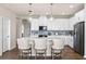 Modern kitchen featuring a large island with bar stools, white cabinets, and stainless-steel appliances at 9292 Sea Pine Ave, Orlando, FL 32832