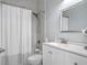 Bathroom featuring tiled shower with rainfall shower head, white vanity, and framed mirror at 9918 Pallida Hickory Way, Winter Garden, FL 34787