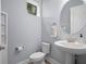 Powder room with a pedestal sink, round mirror, and a modern commode at 9918 Pallida Hickory Way, Winter Garden, FL 34787