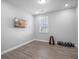 Bedroom featuring neutral walls, wood floors, a window with shutters, and fitness equipment at 9918 Pallida Hickory Way, Winter Garden, FL 34787