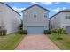 Exterior showcasing a gray two-story home with a blue garage and brick driveway at 9918 Pallida Hickory Way, Winter Garden, FL 34787