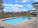 Community pool surrounded by lounge chairs and a wrought iron fence with neighborhood homes in the background at 9918 Pallida Hickory Way, Winter Garden, FL 34787