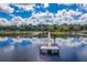 Beautiful aerial view of long dock and seating stretching into a serene lake with reflections of clouds at 105 Lena Ann Dr, St Cloud, FL 34771