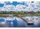 Stunning aerial view of a long dock with seating extending into a serene lake with reflections of clouds at 105 Lena Ann Dr, St Cloud, FL 34771