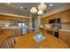 Warm kitchen with wood cabinets, stainless steel appliances, and adjacent dinette beneath stylish pendant lighting at 105 Lena Ann Dr, St Cloud, FL 34771