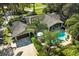 An elevated view of a charming home with a private pool, covered patio, and lush tropical landscaping at 11 Stone Gate S, Longwood, FL 32779