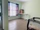 Bedroom featuring wood-look tile flooring, a window, and a simple desk setup at 112 Angeles Rd, Debary, FL 32713