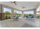 Covered poolside patio with ceiling fans, tables, chairs, and lovely green view at 1224 Big Bass Dr, Ormond Beach, FL 32174