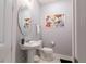 Powder room with pedestal sink, decorative mirror and artwork, and tiled floor at 1507 Carey Palm Cir, Kissimmee, FL 34747