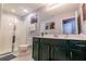 Bathroom with a shower, dark vanity, and large mirror with vanity lights at 1507 Carey Palm Cir, Kissimmee, FL 34747