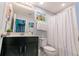 Full bathroom with dark vanity, large mirror, shower, and themed decor at 1507 Carey Palm Cir, Kissimmee, FL 34747
