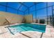 Screened-in pool with a spa, lounge chairs and a paved deck at 1507 Carey Palm Cir, Kissimmee, FL 34747